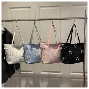 Quilted tote bags in four colors with embroidered bows and diamond pattern details