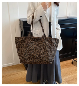 Detail shot of a large leopard print tote bag styled with a white blazer for a chic look