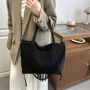 Fashionable black tassel tote bag with hollow woven design for beach and casual use