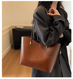 Detailed view of glossy caramel tote bag with sleek leather texture and gold hardware