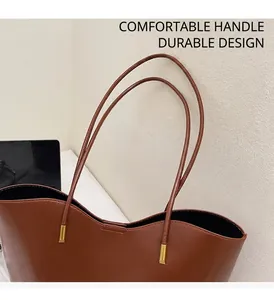 Detail of durable thin straps and glossy dark brown leather on the tote bag