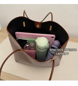 Spacious interior of a brown pebbled leather tote bag holding a tablet and daily items