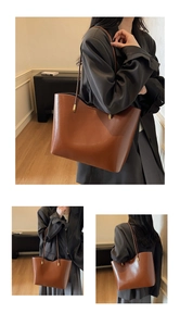 Detail of the brown leather tote bag showing a gold rectangular buckle and smooth finish