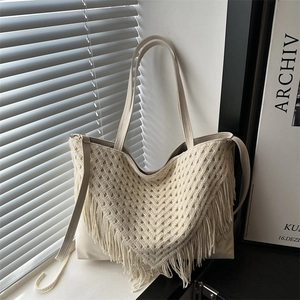 Chic cream white woven beach tote bag with bohemian crochet fringes for seaside vacations