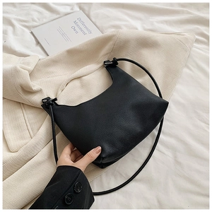 Detail of minimalist black pebbled leather underarm bag with soft half-moon silhouette