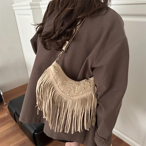 Borsa a mezzaluna in camoscio bohémien con frange e borchie dorate su modella
