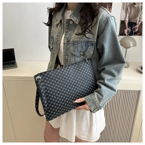 Detail of minimalist envelope clutch bag with grey dot pattern and wrist strap