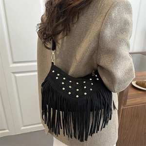 Borsa a tracolla boho in camoscio nero con borchie dorate e lunghe frange sulla modella