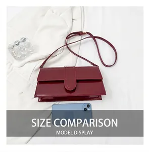 Detail view of burgundy glossy shoulder bag showing size comparison with a smartphone