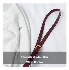 Detail of adjustable wine red leather shoulder strap with gold metal buckle hardware