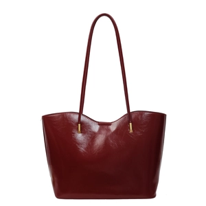 Glossy burgundy leather tote bag with thin shoulder straps and gold hardware detail