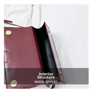 Macro shot of internal structure and golden magnetic closure of the burgundy square bag
