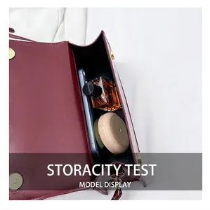 Internal capacity of burgundy leather baguette bag with essentials like phone and perfume