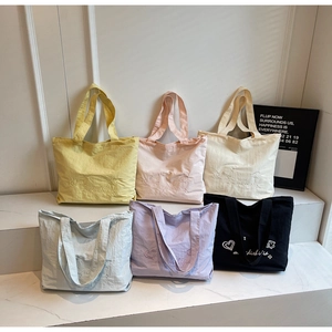 Gros plan de sacs cabas en toile minimalistes en divers coloris avec broderie cœur