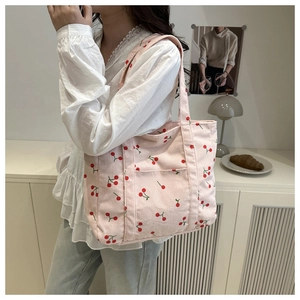 Vue détaillée du sac cabas en velours côtelé rose avec imprimés cerises et poche extérieure