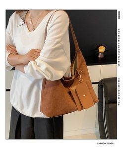 Brown faux suede hobo bag shown on a model in a minimalist interior setting