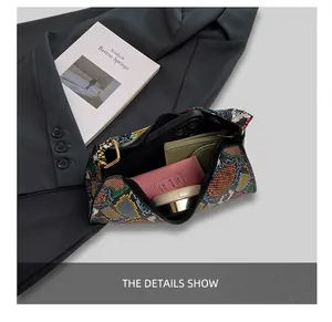 Detail view of snakeskin pattern handbag interior showing storage capacity for phone and cosmetics