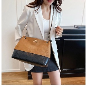 Close-up of quilted leather tote bag with gold twist lock and chain strap detail