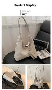 Detail view of grey frosted tote bag with matching detachable mini pouch and gold hardware