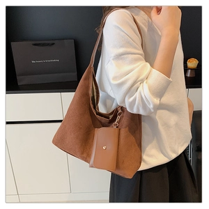 Detail of a brown faux suede tote bag with a small matching pouch and gold hardware