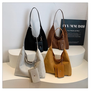 Macro detail of matte leather tote bags with matching mini pouches on minimalist display