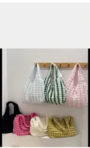 Detail showing various colors of popcorn bubble texture tote bags in soft fabric