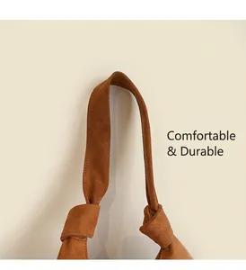 Détail du sac cabas en daim marron avec poignée nouée épaisse et texture douce