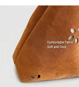 Détail de sac cabas en daim marron avec des motifs floraux ajourés circulaires artistiques