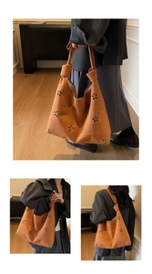 Gros plan du sac cabas en daim caramel avec motifs floraux ajourés et poignée nouée chic