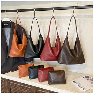Close-up of leather tote bag set with matching zipper pouches in four vintage colors