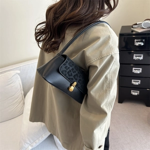 Vintage black leather shoulder bag with leopard print flap and gold clasp detail