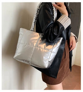 Detail of silver metallic puffer tote bag with quilted square patterns and soft handle