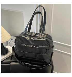 Detail einer schwarzen gesteppten Puffer-Tasche mit weicher Textur und zwei Tragegurten