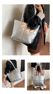 Detail of silver metallic quilted tote bag with wide shoulder straps and soft padded texture