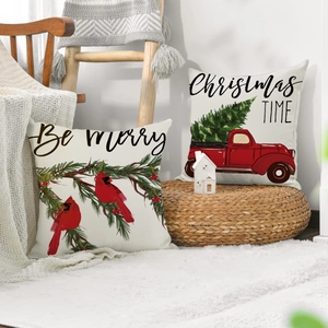Close-up of linen Christmas pillowcases featuring red truck and bird festive designs