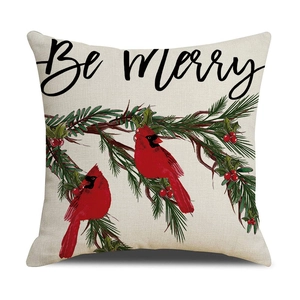 Macro view of linen Christmas pillow cover with red cardinals and Be Merry script