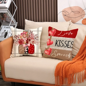 Detail of linen Valentine's Day pillow covers with red heart patterns on a sofa