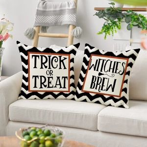 Federe per cuscini di Halloween su divano con scritte Trick or Treat e Witches Brew
