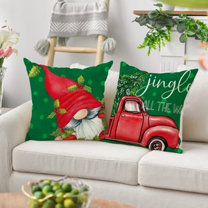 Close-up of Christmas linen pillowcases with festive gnome and vintage truck on sofa