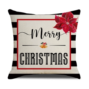 Close-up of linen Christmas pillow cover with poinsettia, gold bells and Merry Christmas text