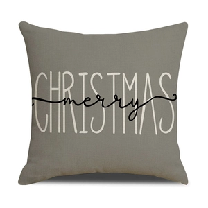Detail of Christmas pillow cover with merry Christmas text on gray linen fabric
