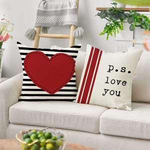 Detalle de fundas de cojín de lino con corazón y texto p.s. love you para San Valentín