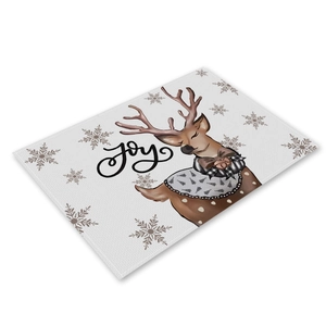 Detail of Christmas linen placemat with reindeer, snowflakes, and festive JOY lettering