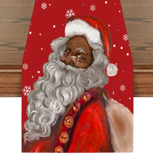 Detail of Christmas table runner featuring Black Santa Claus and white snowflakes on red fabric