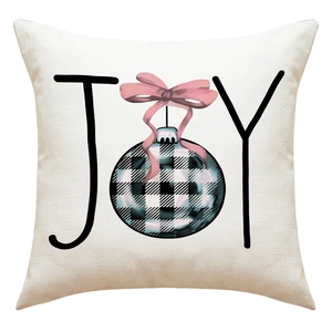 Dettaglio della federa natalizia in lino con scritta JOY e fiocco rosa decorativo