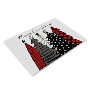 Detailed view of linen placemat featuring hand-drawn Christmas trees and Merry Christmas text