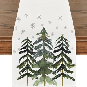 Detail of white Christmas table runner featuring watercolor pine trees and grey snowflakes
