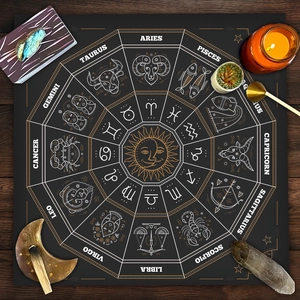 Detail of black velvet tarot cloth showing the white zodiac wheel with sun and moon icons