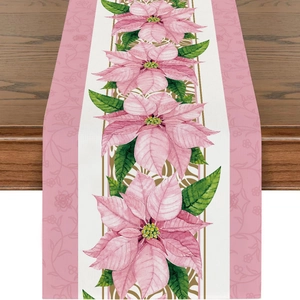 Dettaglio runner da tavola con stelle di Natale rosa e fiori acquerello su legno scuro