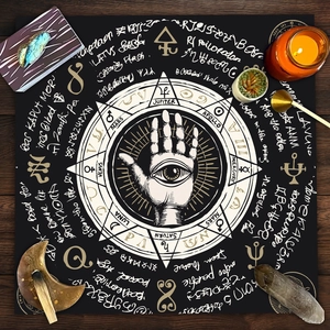 Flat lay of Hamsa Hand tarot tablecloth with crystals and candles on dark wood